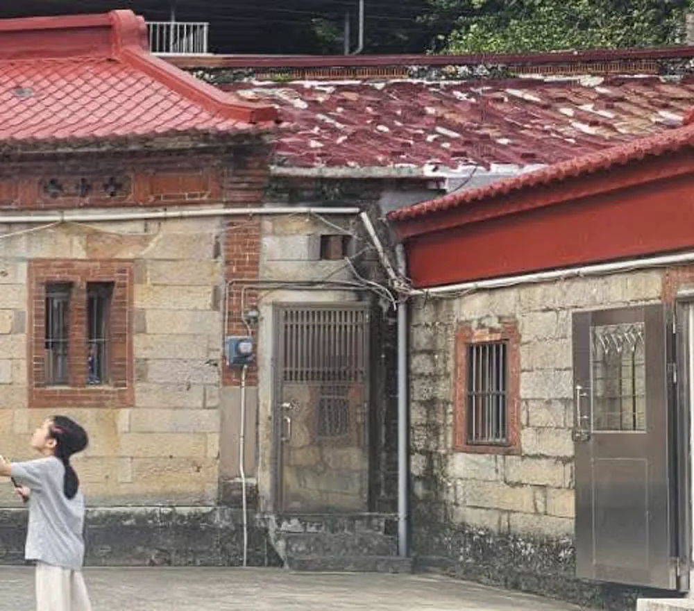 院埕照片裁切，可見右側石砌牆面、窗格與屋簷
